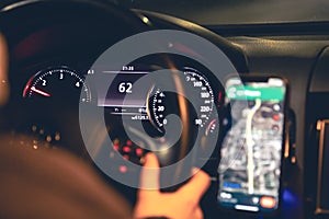 Close-up, steering wheel and navigator in a car at night.