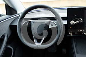 Close up of steering wheel of a new electric vehicle, interior cockpit, electric buttons, digital speedometer