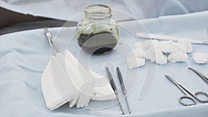 Close up of sterile surgical tools for the surgery. Action. Hand of a medical doctor in protective clean glove taking a