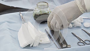 Close up of sterile surgical tools for the surgery. Action. Hand of a medical doctor in protective clean glove taking a