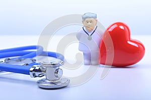 Close-up of stethoscope on background of doctor and red heart. Copy space.