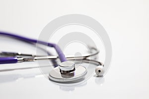 Close-up of stethoscope over reflective white surface