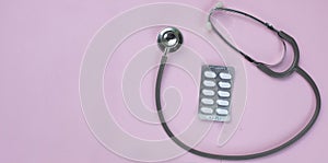 Close up Stethoscope and pill isolate on pink background  .Copy space Medical and health concept