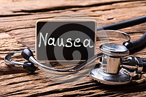 Close-up Of Stethoscope With Slate Showing Nausea Text photo