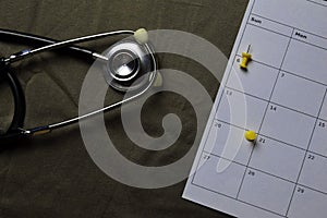Close up stethoscope and stiky notes on a calendar. Schedule or Medical check up concept