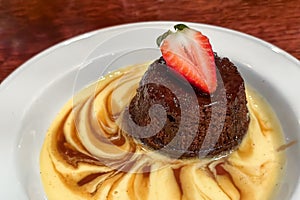 Close up of sticky toffee pudding topped with strawberry