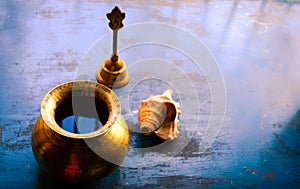 Close up Still Life of antique Holi water pot and bell and Conch shell on rustic floor. Faith, Tradition, Spirituality, Prayer,