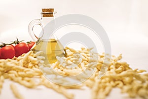 Close up still life of italian handmade pasta fusilli al ferretto with tomato puree and extra virgin olive oil on white background