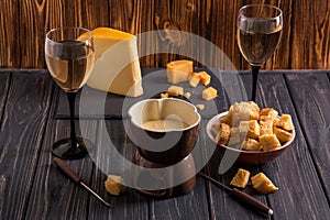 Close up. Still life. Traditional french cheese fondue. Crouton dipped into hot fondue cheese on a long-stemmed fork. Copy space