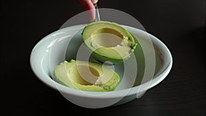 A close-up stock video showcasing a ripe avocado placed on a wooden cutting board