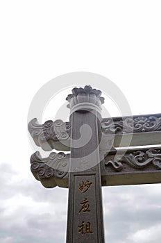 Close-up of stone columns of an archway, relief, flowers, engraved words. Nangshan, Putian City