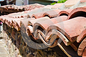Close up of stone fence covered with roof clay tiles in Sozopol, Bulgaria