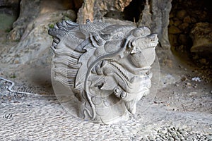 Close-up of a stone sculpture of a dragon head in a park