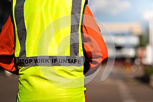 `Stop work if unsafe` on reflective vest for worker. photo