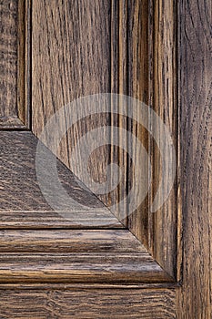 Close up straight on shot of a  detail of paneling and wooden grain on a wooden door