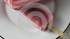 Close up strawberry Ice cream. Slow food movement. Two sticks on plate in black wooden background. Help in hot summer