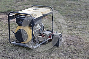 close-up. Street lighting. A gasoline-powered generator that produces current. A car battery is connected for charging. Backup or photo