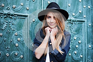Close up street portrait of cute young smiling happy lady wearing stylish wide-brimmed hat. Model looking at camera