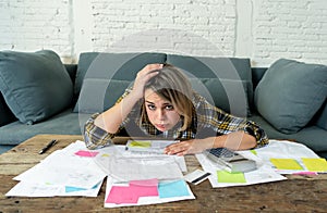 Close up of stressed and overwhelmed young woman paying bills and managing home finances