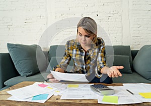 Close up of stressed and overwhelmed young woman paying bills and managing home finances