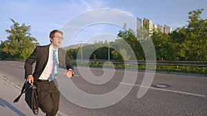 CLOSE UP: Stressed young male manager running to an important business meeting.