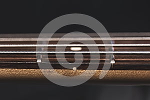 Close-up of strings on the fretboard of a bass guitar
