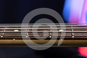 Close-up of strings on the fretboard of a bass guitar