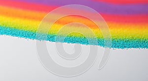 Close-up of stripes of rainbow colored sand in vivid primary colors in high resolution and high sharpness