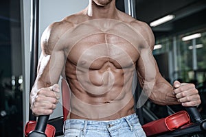 Close up strong abs guy showing in the gym muscles
