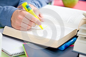 Close-up of a student highlighting a sentence
