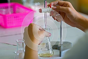 Close-up of a student performing an acid-base titration experiment.