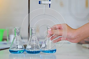 Close-up of a student performing an acid-base titration experiment.