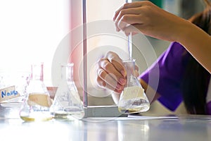 Close-up of a student performing an acid-base titration experiment.