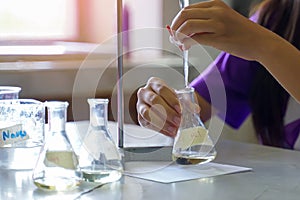 Close-up of a student performing an acid-base titration experiment.
