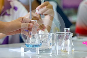 Close-up of a student performing an acid-base titration experiment.