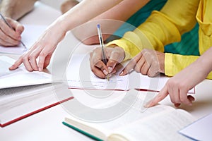 Close up of students hands writing to notebooks