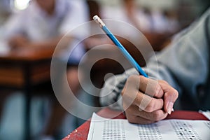 Close up Students writing and reading exam answer sheets exercises in classroom of school with stress