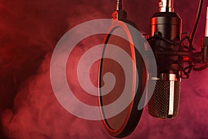 Close-up. Studio condenser microphone Radio, vocals, podcasts red smoke. Copy space photo