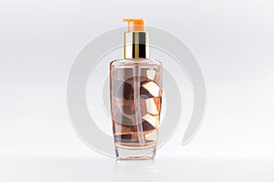 Close-up of studio picture of dispenser glass bottle with luxury cosmetic haircare serum elixir oil, isolated on white background.