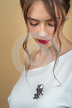 Close-up studio portrait of a girl advertising an authentic silver brooch