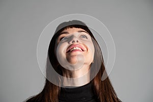 Close up studio portrait of a young woman against plain grey background