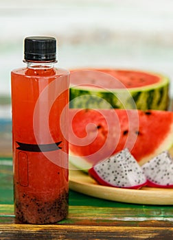 Close up studio shot of sweet delicious healthy sliced watermelon and fresh ripe cold dragon fruit juice in glass placed on wood