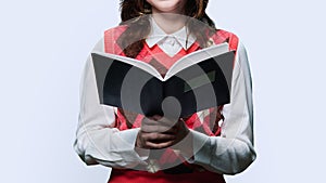 Close-up of study book in hands of young female, on white background