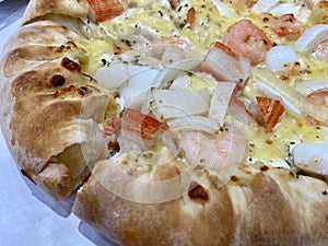 Close-up of stuffed seafood pizza with cheese, onion, prawn, squid, and crab stick. Stuffed crust pizza with Cheese