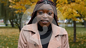 Close-up stunned african american woman standing outdoor looking at camera with eyes wide open and mouth feeling shock