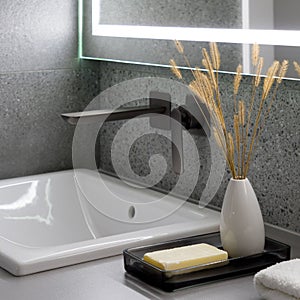 Close-up on stylish bathroom decorations next to washbasin