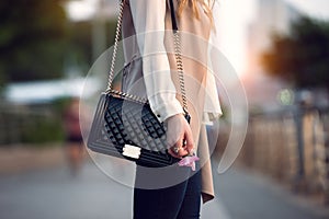 Close up of stylish female black leather bag outdoors. Fashionable and luxury style expensive female bag