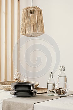 Close-up of stylish rattan lamp above table