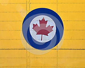 Close-up of  stylized red maple leaf in a white circle bordered by blue, insignia of the RCAF.