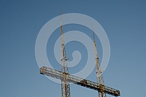 Close-up of a substation with high-voltage power lines against a blue sky at sunset